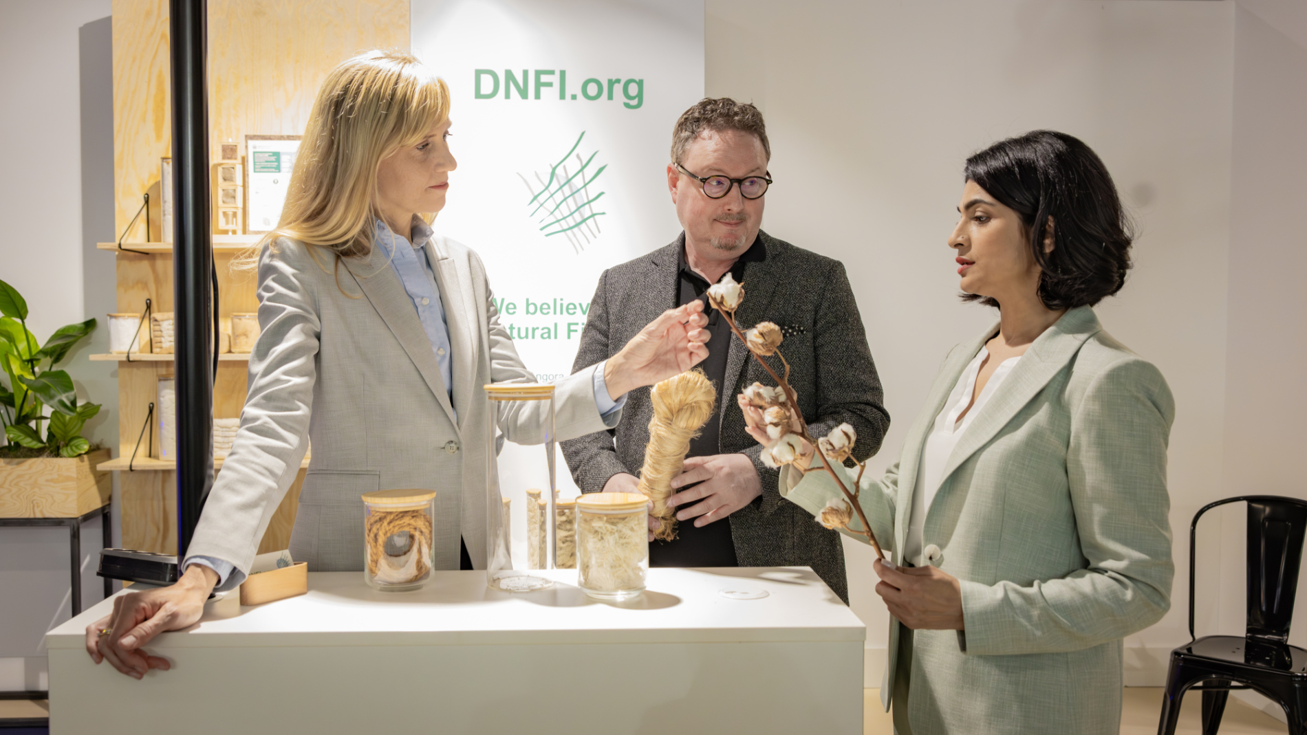 Drei Personen betrachten Naturfasern und textile Rohstoffe