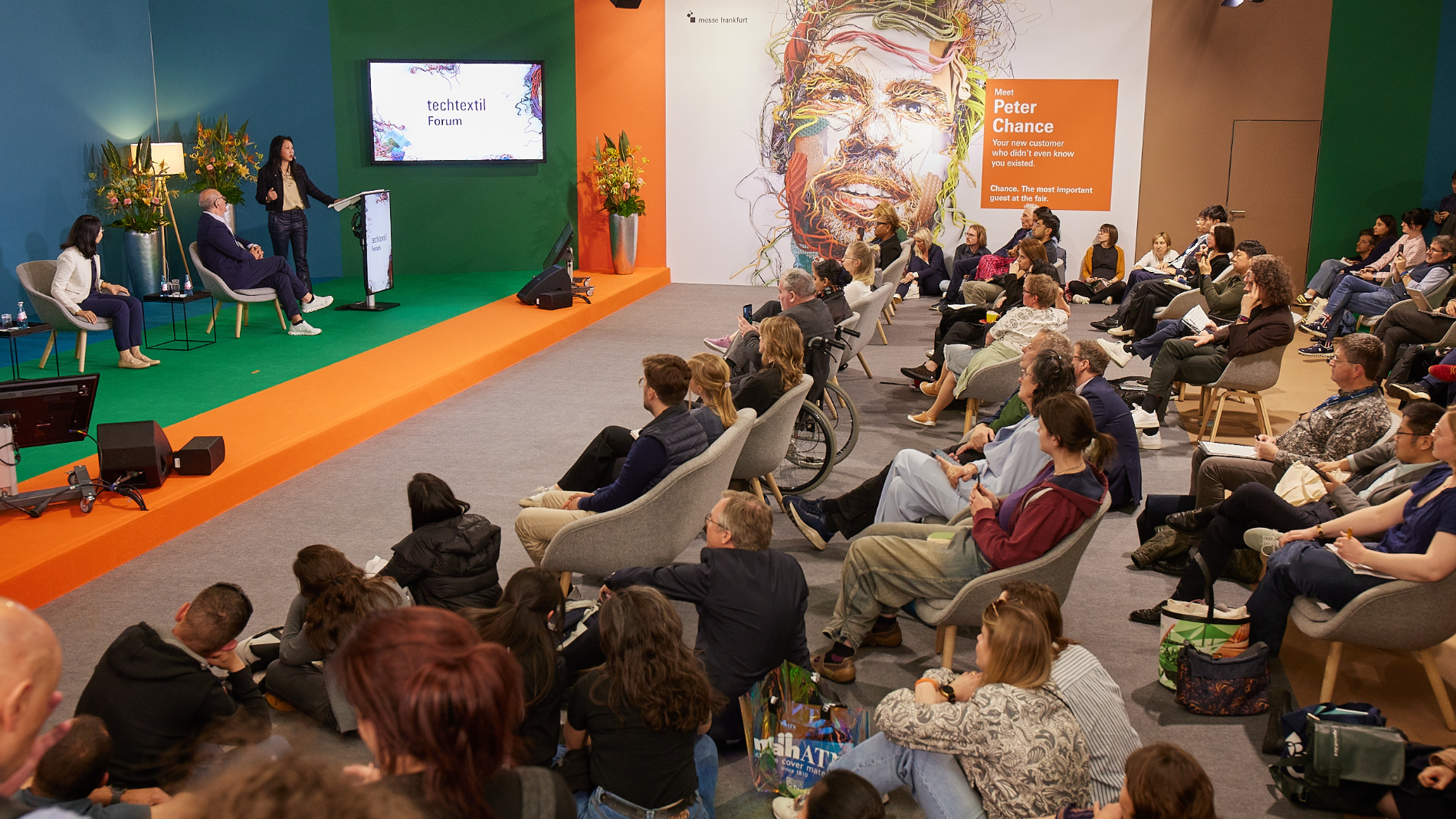 Besucher verfolgen eine Präsentation auf dem Techtextil Forum