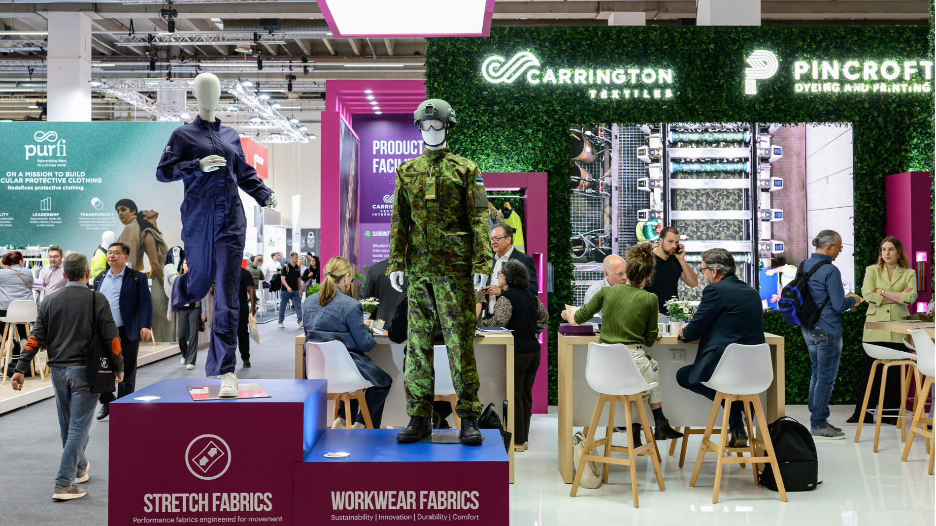 Besucher treffen sich an einem Messestand für technische Textilien und Workwear-Stoffe